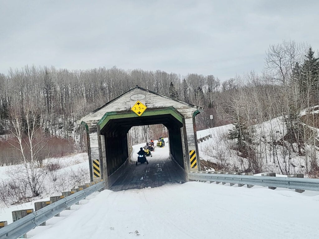 sentier motoneige passant sous un pont couvert dans la secteur de La Sarre